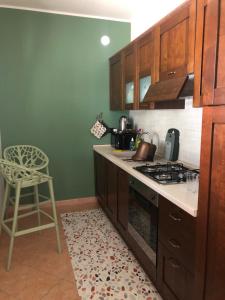 Una cocina con una estufa y una silla dentro. en Casa vacanze 365 - verde, en Tortoreto Lido 4 fotos más