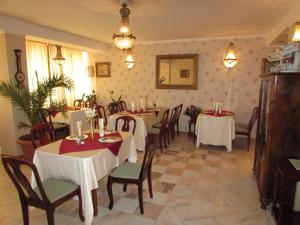 a dining room with white tables and chairs and flowers at Pension Dinu Residence in Timişoara +13 photos