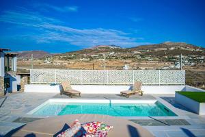 una piscina con due sedie a sdraio e una piscina di Irenes View Apartments ad Agia Irini Paros