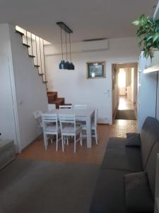 comedor y sala de estar con mesa blanca y sillas en Lucca Old Town Apartment, en Lucca