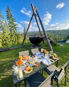 una mesa de picnic con comida y un barco en el fondo en Tatra Glamp Bukowina Tatrzańska - Sieć noclegowa Tatra Glamp, en Bukowina Tatrzańska