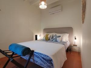 a bedroom with a large bed with blue and white sheets at WelcomeBuddy - Villa Wave N'Sea - Beachfront in Mosteiros