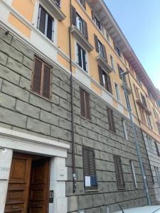 ローマにあるMaison Cavalleggeriの茶色のドアと窓が施された建物