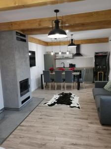 a living room with a fireplace and a dining room at Apartament NA PIĘTERKU in Rzepiska