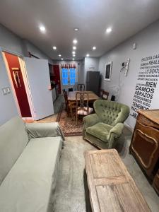 salon ze stołem i zieloną kanapą w obiekcie Habitaciones Garay 3100 w mieście Mar del Plata