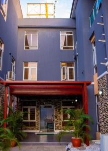 a blue building with plants in front of it at Dozubel Hotel in Abuja