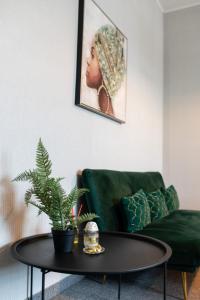 - un salon avec un canapé vert et une table dans l'établissement Central Square Apartments, à Belgrade