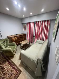 een slaapkamer met een bed, een bureau en een stoel bij Habitaciones Garay 3100 in Mar del Plata