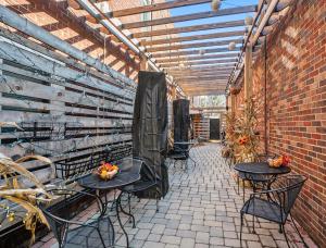 a patio with tables and chairs and a brick wall at Historic Hotel Nichols in South Haven