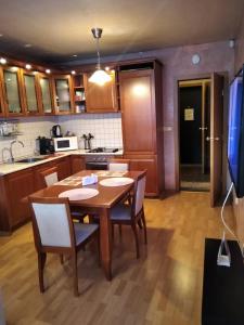 - une cuisine avec une table et des chaises en bois dans la chambre dans l'établissement Апартамент Мур, à Sofia