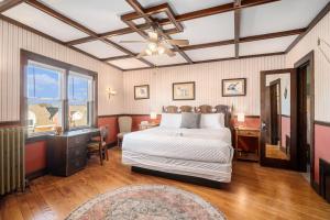 a bedroom with a bed and a desk and a window at Historic Hotel Nichols in South Haven