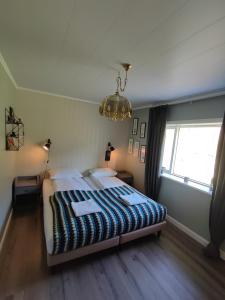 een slaapkamer met een bed, een raam en een kroonluchter bij Hóll in Óbyggðasetur