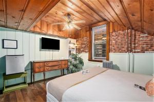 a bedroom with a bed and a flat screen tv at Historic Hotel Nichols in South Haven