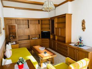 a living room with wooden cabinets and a green table at Ferienwohnung Sonnwendhof "Kellerjochblick" in Schwaz