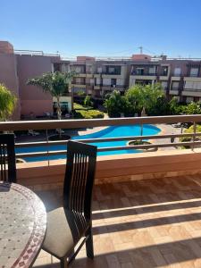 een zwembad met 2 stoelen en een tafel op een balkon bij LUXURY APPART Pool view Riad Garden in Marrakesh