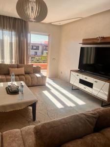 een woonkamer met een grote flatscreen-tv bij LUXURY APPART Pool view Riad Garden in Marrakesh