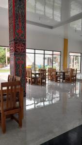 Habitación con sillas, mesas y ventanas de madera. en Hotel Barbara en Tuk Tuk