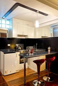 a kitchen with white cabinets and red bar stools at Allincay Cusco Apart Hotel in Cusco