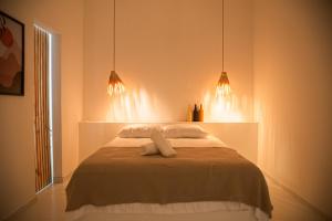 een slaapkamer met een bed met twee handdoeken erop bij Casa privativa na Vila Ser tão zen #02 in Tibau do Sul