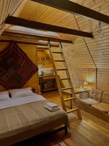 Kazbegi Kuro Cottages في كازباجي: غرفة نوم مع سرير بطابقين وسلم