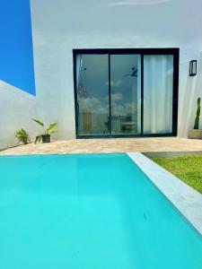 een blauw zwembad voor een huis bij Casa privativa na Vila Ser tão zen #02 in Tibau do Sul