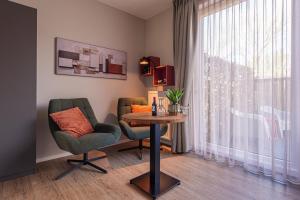 salon ze stołem i krzesłami oraz oknem w obiekcie Villa Zoutelande w mieście Zoutelande