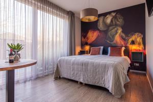 ザウテランデにあるVilla Zoutelandeのベッドルーム1室(ベッド1台付)が備わります。壁には絵画が飾られています。