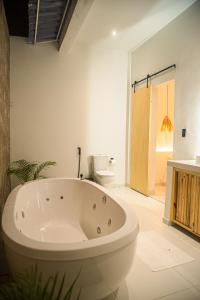 uma banheira na casa de banho com WC em Casa com piscina privativa Praia da Pipa #2 em Tibau do Sul