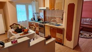 a kitchen with a sink and a stove top oven at Apartament 3 camere Slanic Moldova. priveliste deosebita! 200m pârtie in Slănic-Moldova