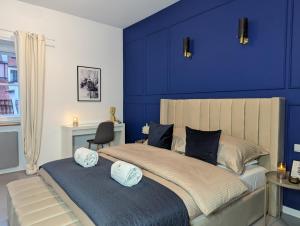 una camera da letto con pareti blu e un letto con due cuscini di Bella Luna Luxury Suites - Chic Residence in Historic Square a Varsavia