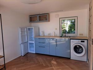 a kitchen with a washing machine and a sink at Jūrmalciema Namiņi in Jūrmalciems