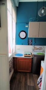 eine kleine Küche mit blauen Wänden und einem Fenster in der Unterkunft Mesnil Val Plage in Criel-sur-Mer