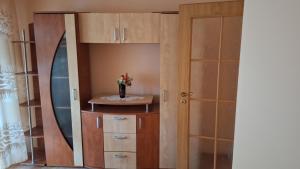 a closet with a cupboard and a vase of flowers at Apartament 3 camere Slanic Moldova. priveliste deosebita! 200m pârtie in Slănic-Moldova +4 photos
