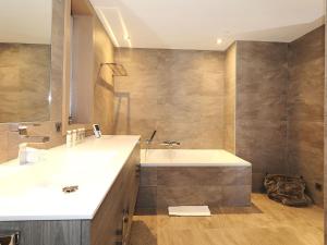 une salle de bain avec un lavabo et une baignoire dans l'établissement Chalet de luxe avec jacuzzi et garage à Courchevel - FR-1-563-30, à Courchevel
