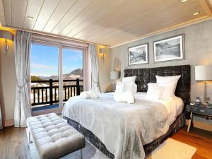 une chambre avec un grand lit avec une grande fenêtre dans l'établissement Chalet de luxe avec jacuzzi et garage à Courchevel - FR-1-563-30, à Courchevel