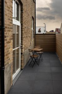 patio ze stołem i krzesłami w ceglanym budynku w obiekcie Deluxe North Central London Apartment w Londynie