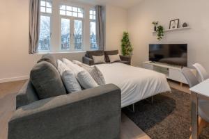 ein Schlafzimmer mit einem Bett, einem Sofa und einem TV in der Unterkunft Deluxe North Central London Apartment in London