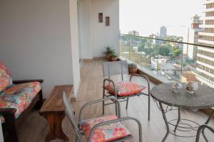 a living room with a table and chairs and a balcony at Exclusivo departamento con Vista al Río - Edificio Marwa - Posadas in Posadas
