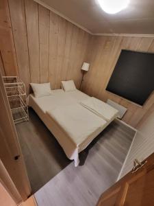 1 dormitorio con 1 cama en una habitación de madera en 6 Bedrooms, 8 Guest Apartment in Kjeller Lillestrøm - 5mins from Lillestrøm Station, 3 mins to OSLOMET, en Lillestrøm