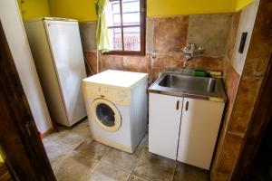 una pequeña cocina con lavadora y fregadero en Alojamiento Del Bosque en Ushuaia