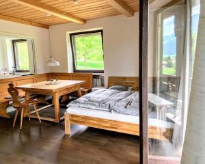 - une chambre avec un lit, une table et une fenêtre dans l'établissement Haus Oberwössen, à Unterwössen