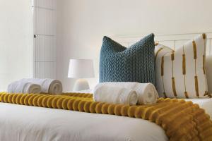 a bed with two blankets and pillows on it at Gordonia 10 by HostAgents in Gordonʼs Bay