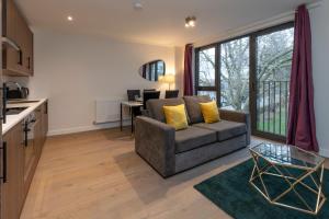ein Wohnzimmer mit einem Sofa und einem Tisch in der Unterkunft Deluxe North Central London Apartment in London