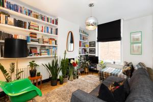 ein Wohnzimmer mit einem Sofa und Bücherregalen in der Unterkunft Unique stylish 1BR flat near Columbia Road in London