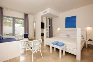 ein weißes Schlafzimmer mit einem Bett und einem Balkon in der Unterkunft Meditur Puglia by Itafirst Hotels in Specchiolla 