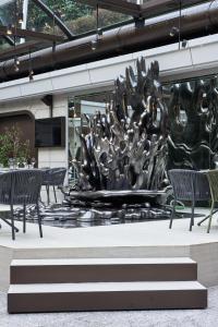 a large metal sculpture in a building with chairs at VP Madroño in Madrid +37 photos
