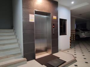 een metalen lift in een gebouw met een trap bij Apartamento CENTRO de Loja. in Loja