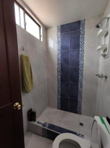 een badkamer met een douche, een toilet en een raam bij Apartamento CENTRO de Loja. in Loja