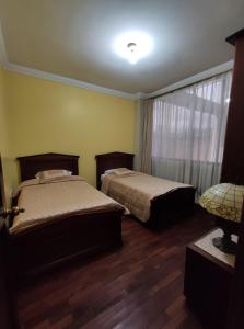 een slaapkamer met 2 bedden en een raam bij Apartamento CENTRO de Loja. in Loja