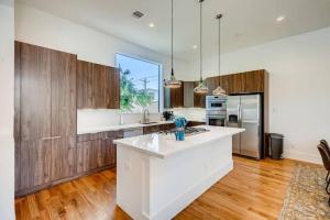 a kitchen with a white counter top and wooden cabinets at 4 Story Modern Home Sleeps 10 - DT Views! in Houston